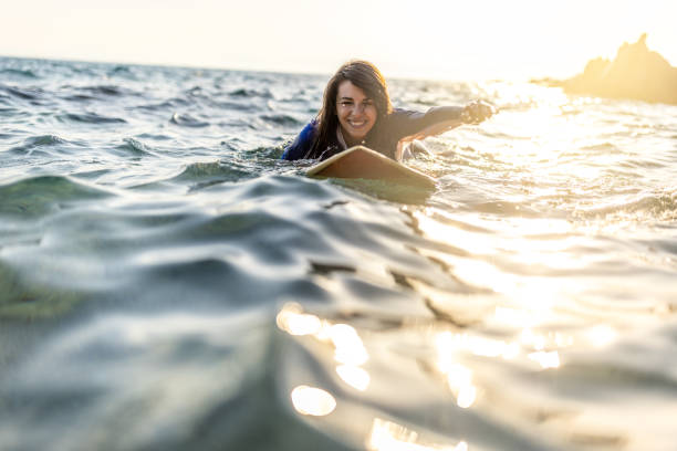 istock Woman in wetsuit with a surfboard 1496113759