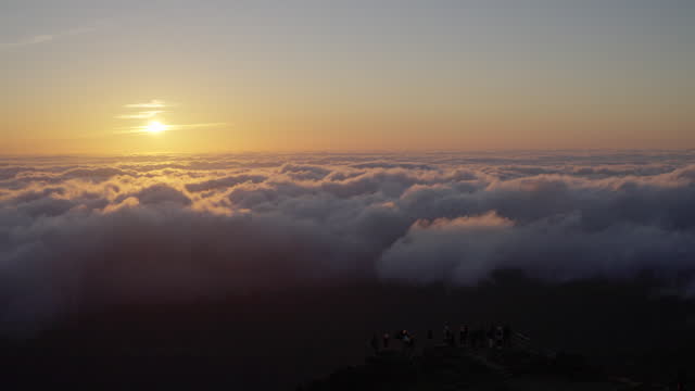 Beautiful view of sun setting above sea of clouds