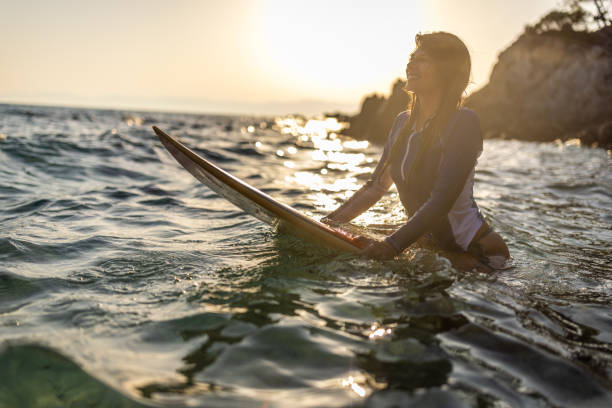 istock Woman in wetsuit with a surfboard 1496114004