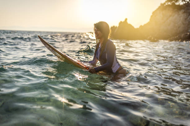 istock Woman in wetsuit with a surfboard 1496114540