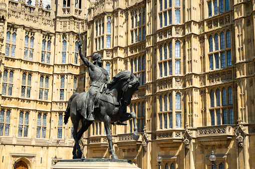 The iconic statue of Richard the Lionheart, King of England (created by Baron Carlo Marochetti) standing in front of the Palace of Westminster in London.