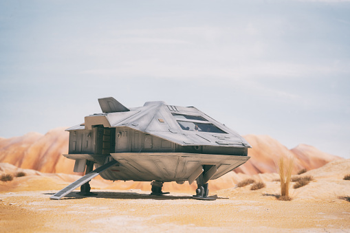 A small and battered spaceship has landed on a dusty planet. Scale model photography.