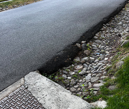 Asphalt road and drainage ditch rocks
