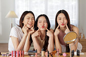 Three Asian women exude confidence as showcase radiant skin.