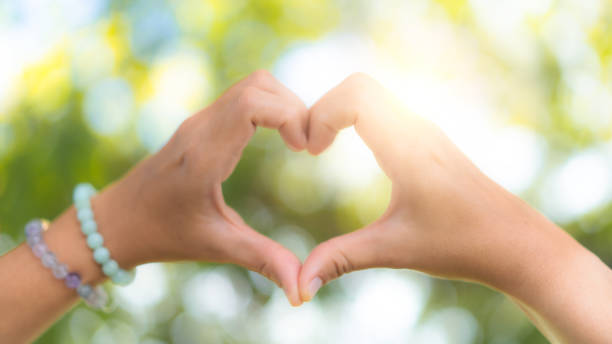 istock Hand do heart shape mean love on nature bokeh background. 1496121233
