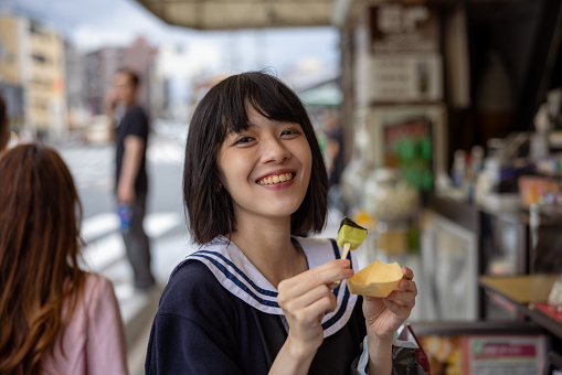 Happy woman eating street food - Nama-fu skewers