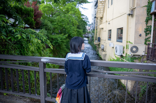 Rear view of woman standing on bridge