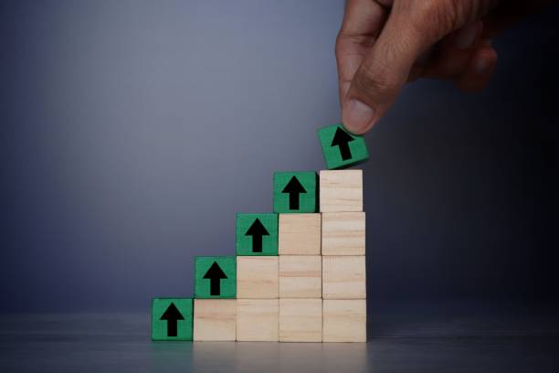 istock Hand put wooden cube with upward arrow sign. 1496124503
