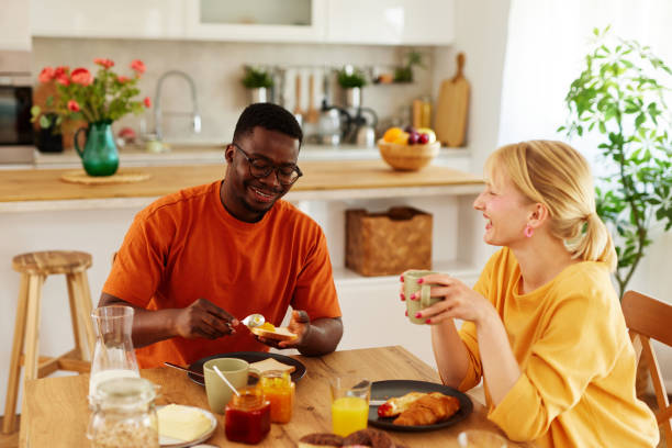 istock Multiracial couple enjoying breakfast together at home 1496125826