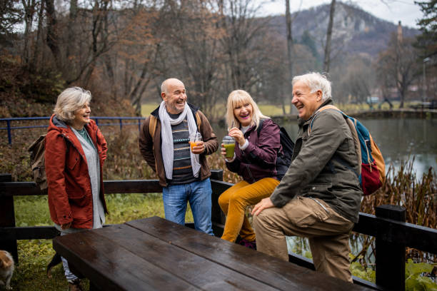 Old friends Group of people, two mature couples together on a cloudy autumn day together. dog disruptagingcollection stock pictures, royalty-free photos & images