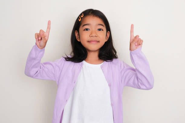 istock Asian little girl smiling and pointing both hands up 1496127405