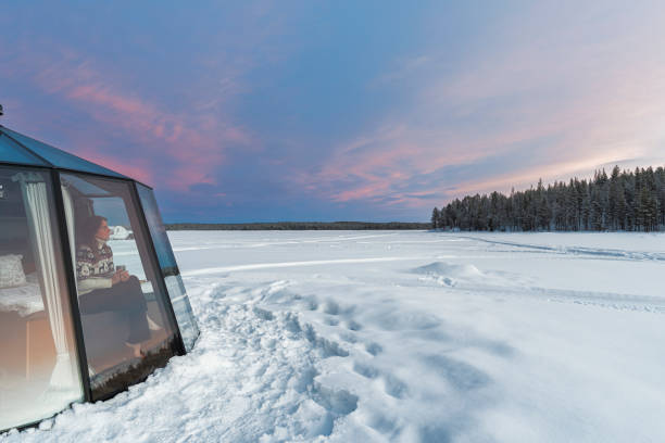 osoba podziwia zachód słońca ze szklanego igloo, laponii - winter landscape sweden snow zdjęcia i obrazy z banku zdjęć