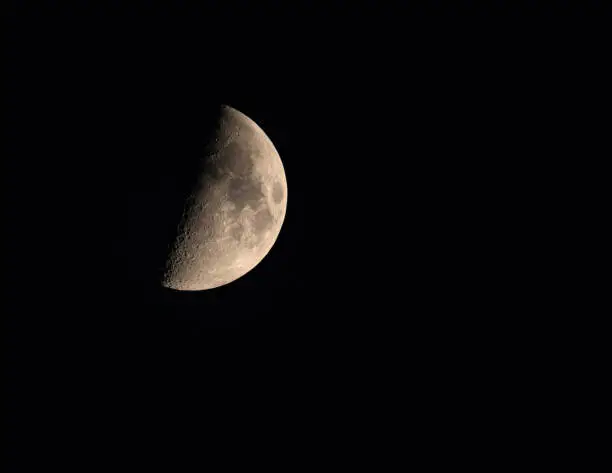 moon in the night dark sky in the first quarter closeup