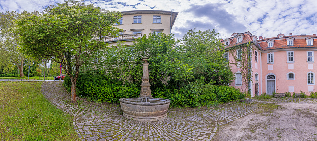 Picture of historical stone fountain on cobblestones in springtime