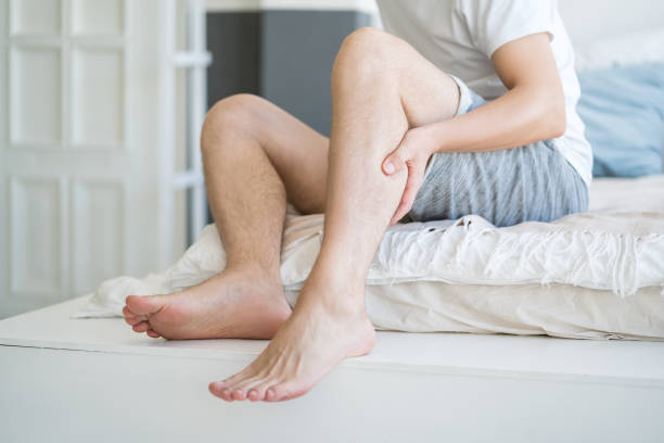 The man's calf muscle cramped, massage of male leg at home The man's calf muscle cramped, massage of male leg at home, painful area highlighted in red human leg muscle stock pictures, royalty-free photos & images