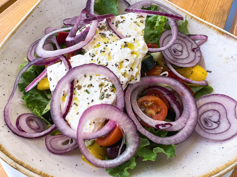 Traditional Greek salad with feta cheese, tomatoes, pepper, cucumber, olives, oregano and olive oil.