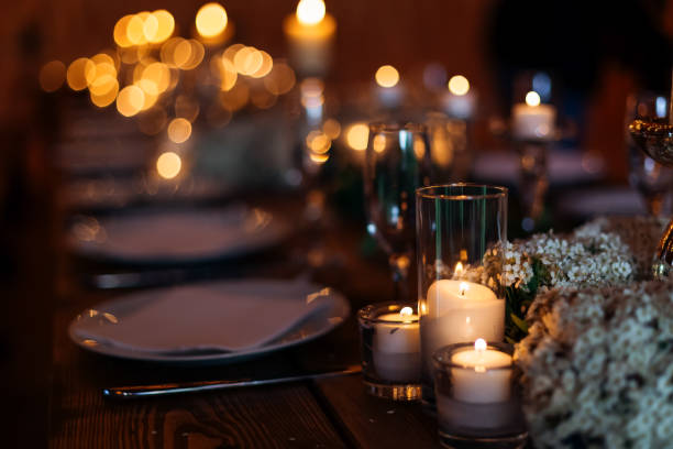 istock Candles on wedding table set on a beautiful lit background. Forget-me-not flowers lit by candles on wooden table 1496129657