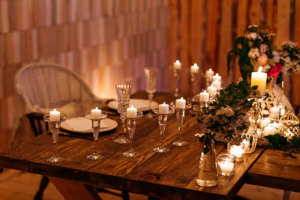 istock Candles in the flasks set on table decorations surrounding plates at cozy warm atmosphere 1496129659