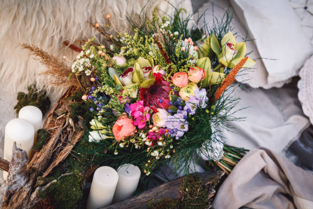 istock Wedding bouquet in boho style laying on the sand near textured tree bark 1496129707