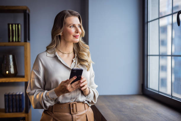 Women leader in her business Portrait of a confident mature businesswoman working in a modern office. older blonde woman stock pictures, royalty-free photos & images