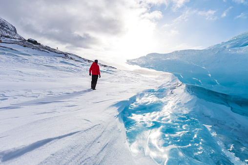 Rear view of a hiker in the white and icy landscape of the artic