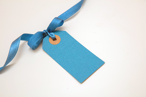 Blank blue price tag isolated on transparent background. Pastel color empty gift card and ribbon bow,