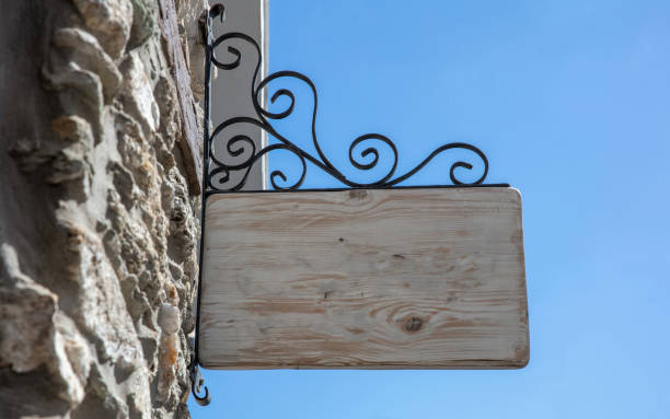 istock Empty wooden sign hanging from a metal structure, blue sky. Under view, copy space, ad template 1496131845