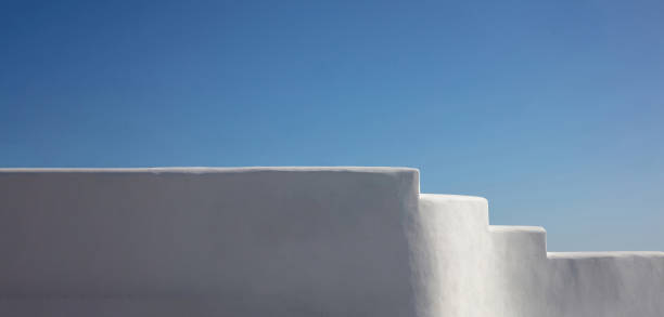 istock Exterior white building empty wall touches blue sky background, Greece Cyclades island. Copy space 1496131859