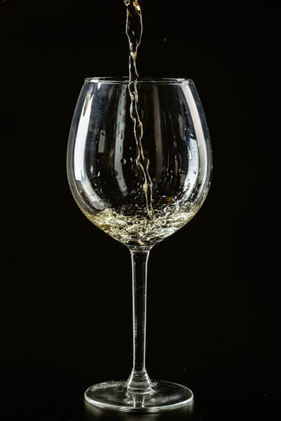 istock White wine being poured in a wine glass on a dark background 1496131950