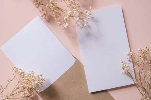 istock White blank greeting or invitation card and envelope with gypsy flower decoration on Old Rose background. Mock up presentation. 1496132121