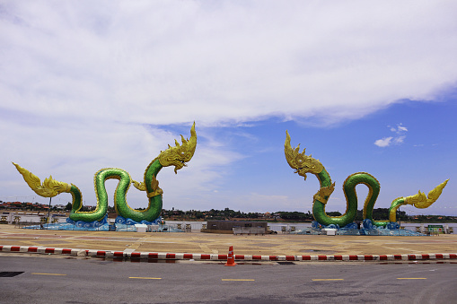 Twin Naga statue in the blue sky and white cloud background, in Nong Khai, Thailand.