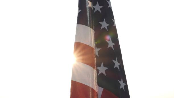 Close up waving American USA flag on natural outdoor setting with sun ray flare nature outdoor background. Fourth of July, Independence Day, 4th of July, Memorial Day, Veterans Day, Labor Day Concept de cerca ondeando la bandera estadounidense de ee. uu. en un entorno natural al aire libre con un fondo exterior de destellos de rayos solares. cuatro de julio, día de la independencia, 4 de julio, día de los caídos, día de los veteranos, concepto del