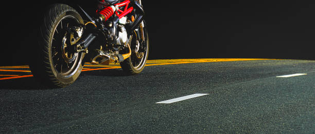 Motorbike parked on paved road with black background, copy space for individual text.