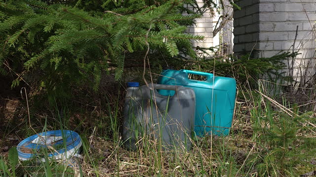 Two big gasoline container on the grassy lawn in Estonia