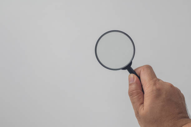 istock hand holding a magnifying glass on a white background 1496141978