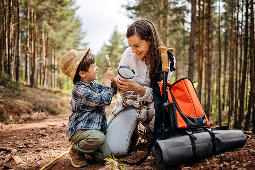 Mother and son explore nature, look with a magnifying glass