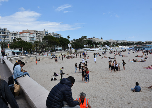 Crowds colorful of people enjoying a sunny day in the Copacabana Beach. The skyline of Rio de Janeiro can be seen.