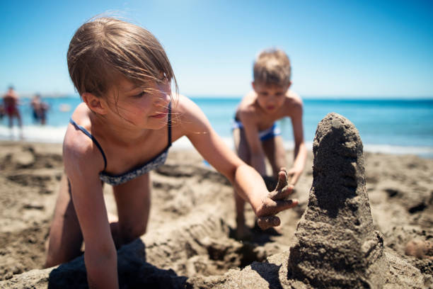 istock Two kids building sandcastles on the beach 1496152540