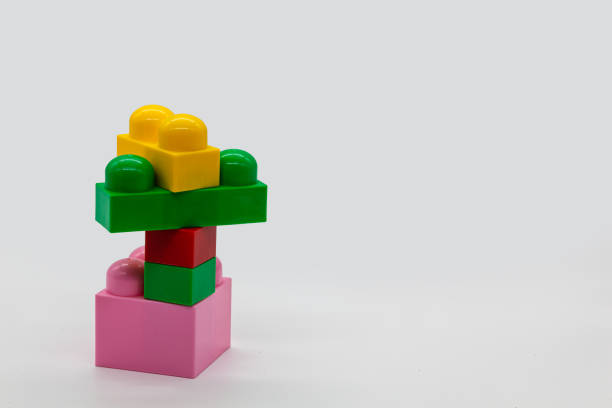 Children's toy constructor plastic building block different sizes. Red, pink and yellow and green blocks. Photo in high quality. Isolated.
