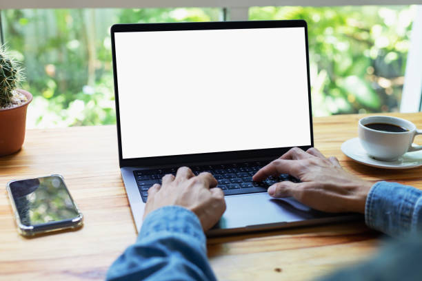 istock mock up empty screen notebook, businessman working on his laptop computer with blank space screen for advertising text on wood desk in Cafe 1496153990