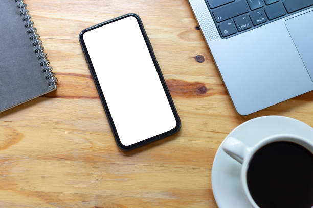 istock Top View Work space office desk, mockup empty screen smartphone on wooden table. with clipping path, with blank space screen for advertising text 1496153998