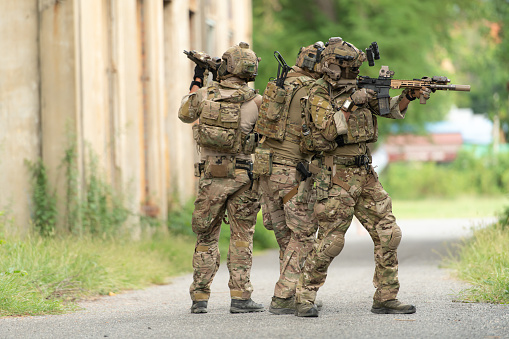 Soldier in camouflage with a pair of weapons that are full of modern technology and complete for battle