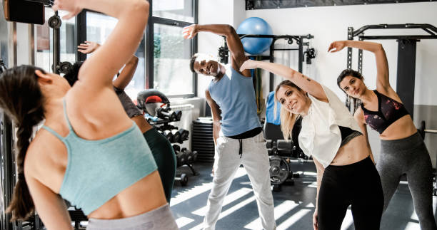 istock Cheerful sportspeople doing bending exercise together 1496161200