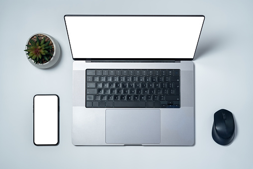 Modern laptop and smartphone with a blank white screens. Directly above view. Realistic mockup for your design.