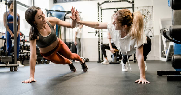 istock Happy sportswomen giving high five while doing plank exercise 1496161819