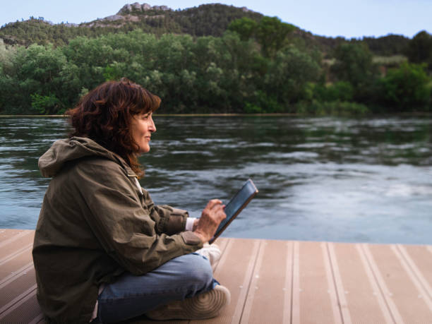 istock woman with tablet on a jetty 1496162158