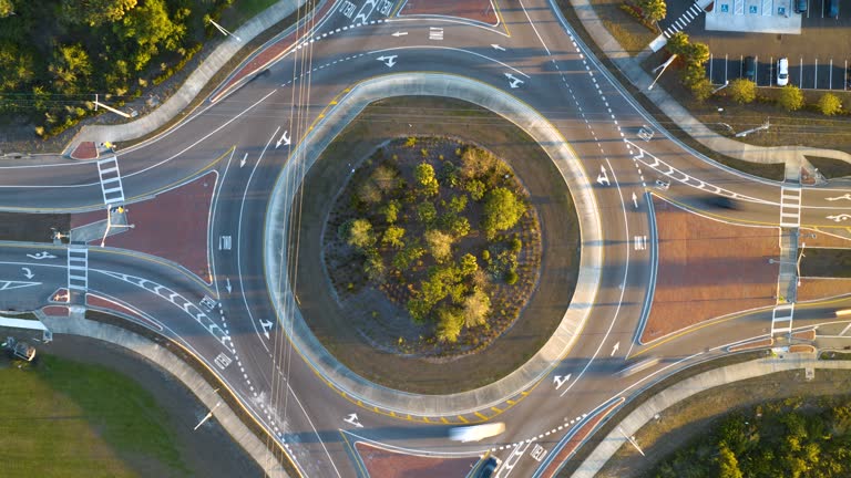 Aerial view of road roundabout intersection with fast moving heavy traffic. Timelapse of urban circular transportation crossroads