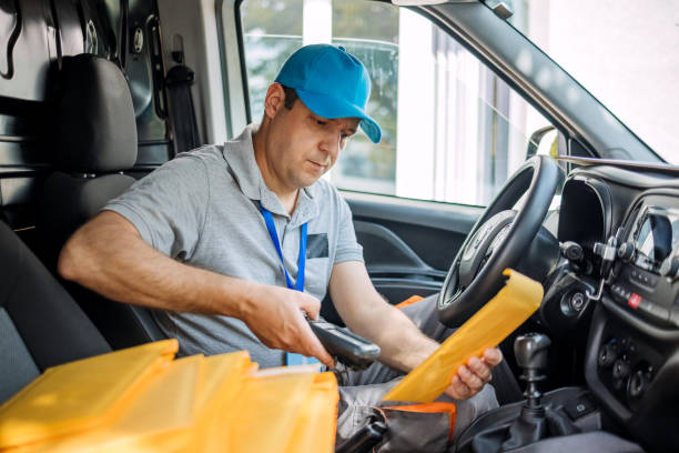 istock Man working in delivery service using scanner for delivery confirmation 1496164962