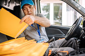 Man working in delivery service using scanner in vehicle interior