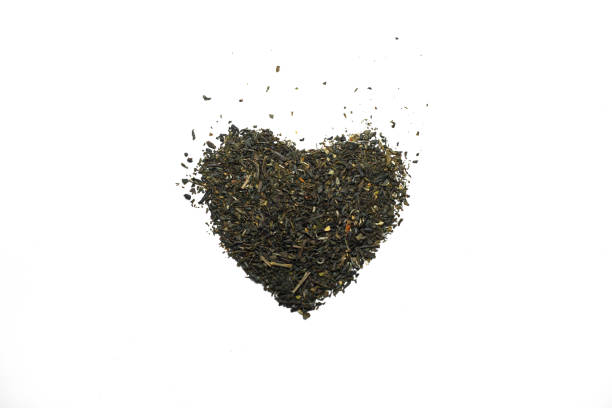 istock Dried tea arranged in a heart shape close-up with white background. 1496167894